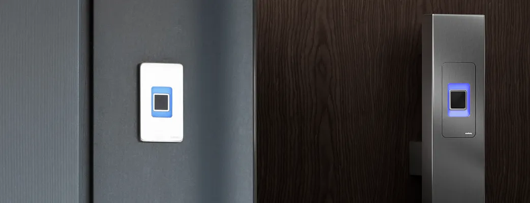 Two illuminated fingerprint readers, one on a white door and one on dark wood, shown side by side