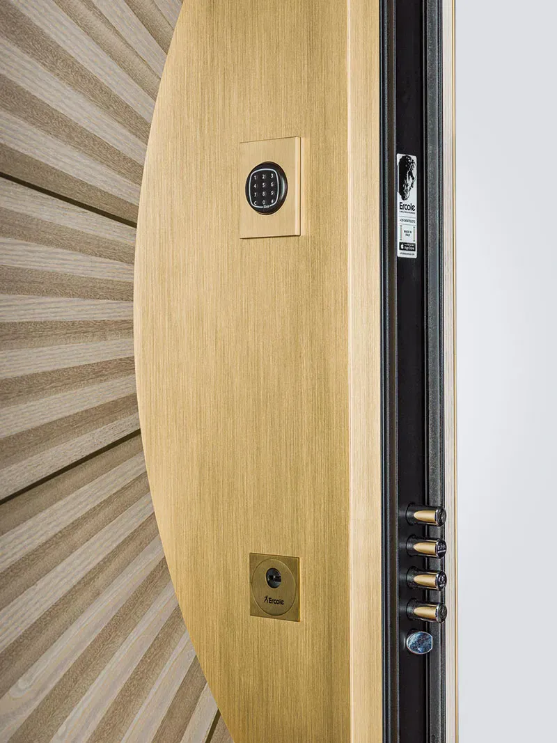 Brushed-brass security door with a keypad entry and brass deadbolt bolts along the edge