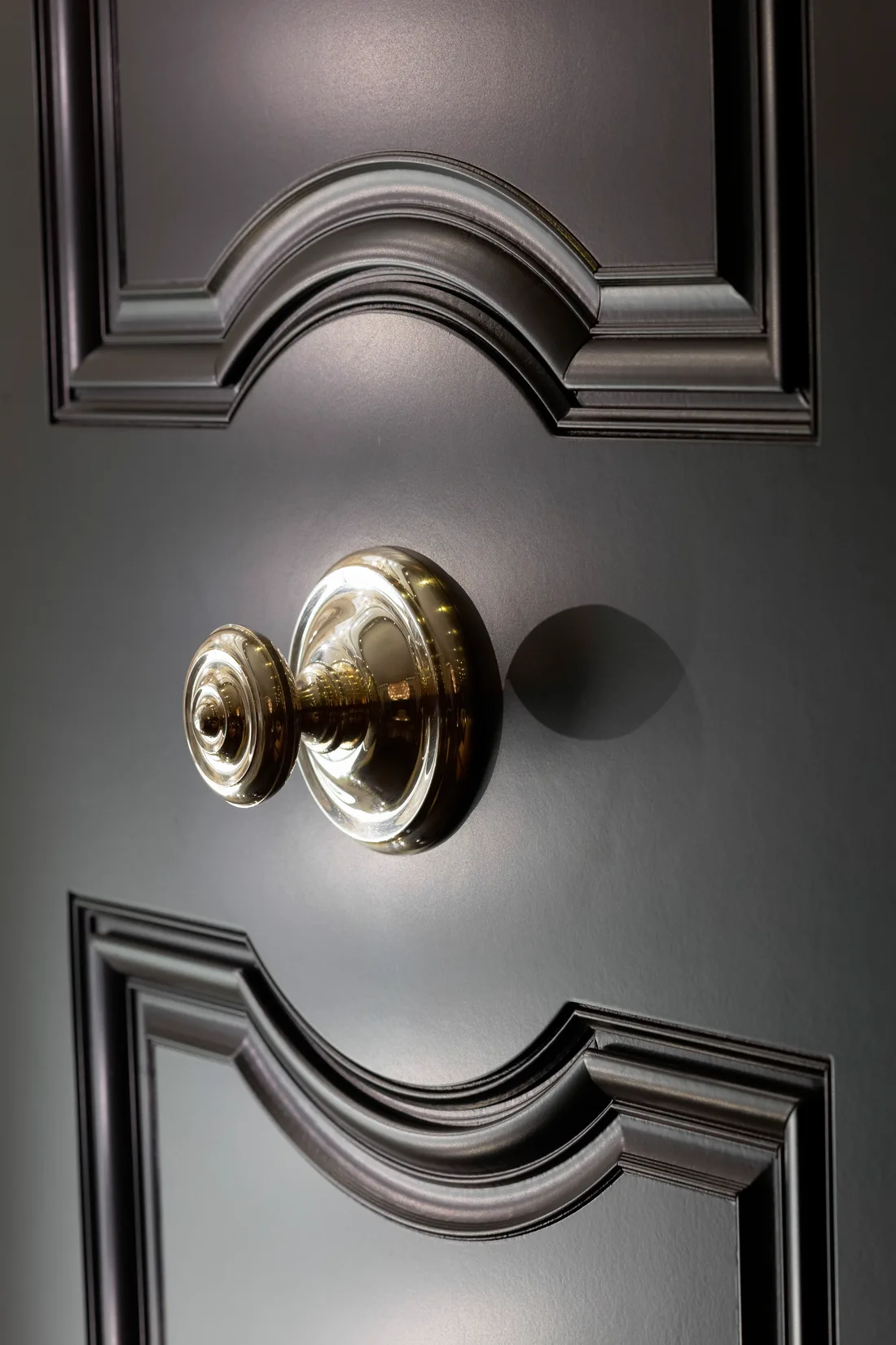 Close detail of a panelled door with a polished brass knob
