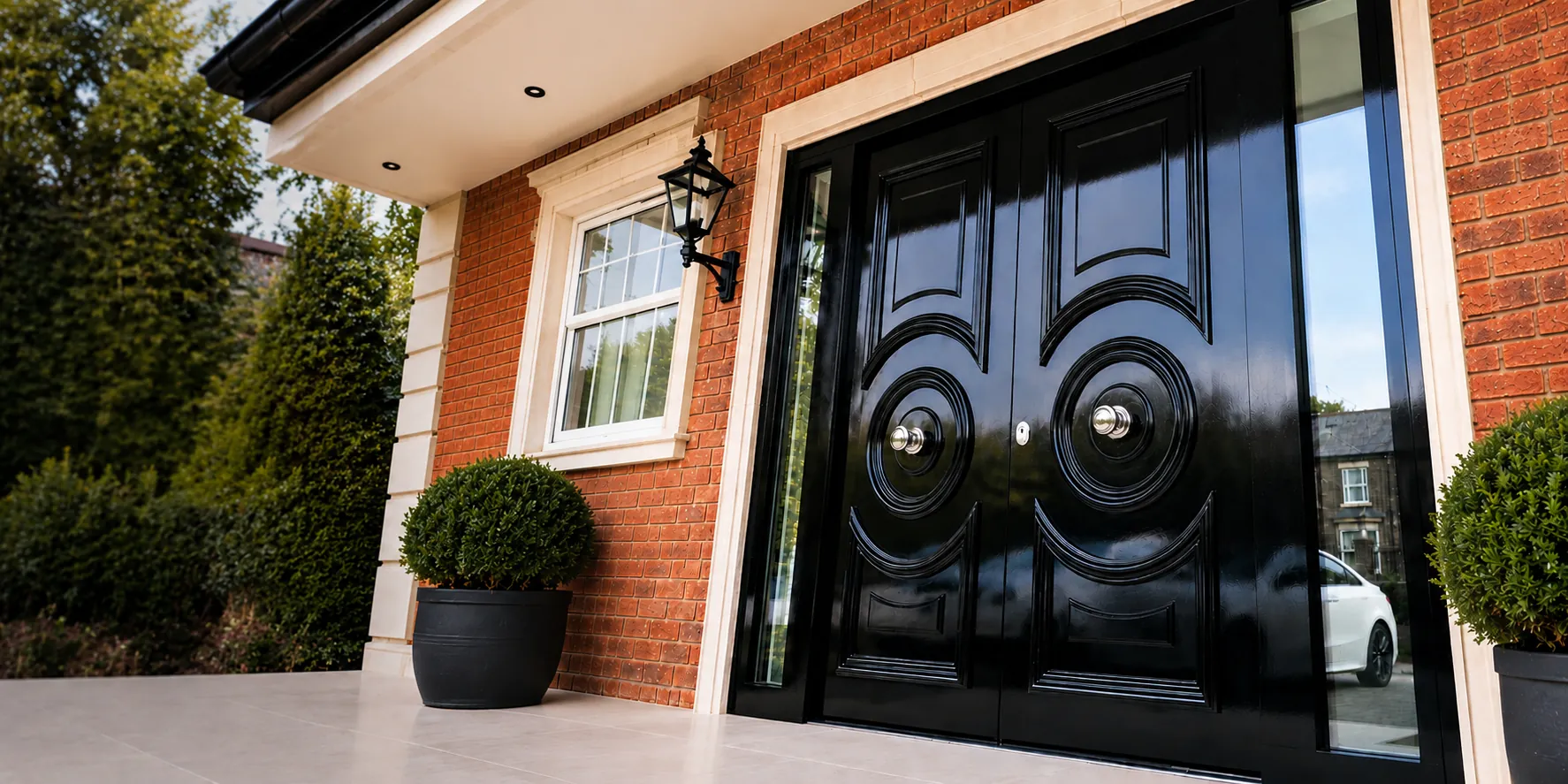 Black gloss double-leaf steel security front door with brass furniture and sidelights