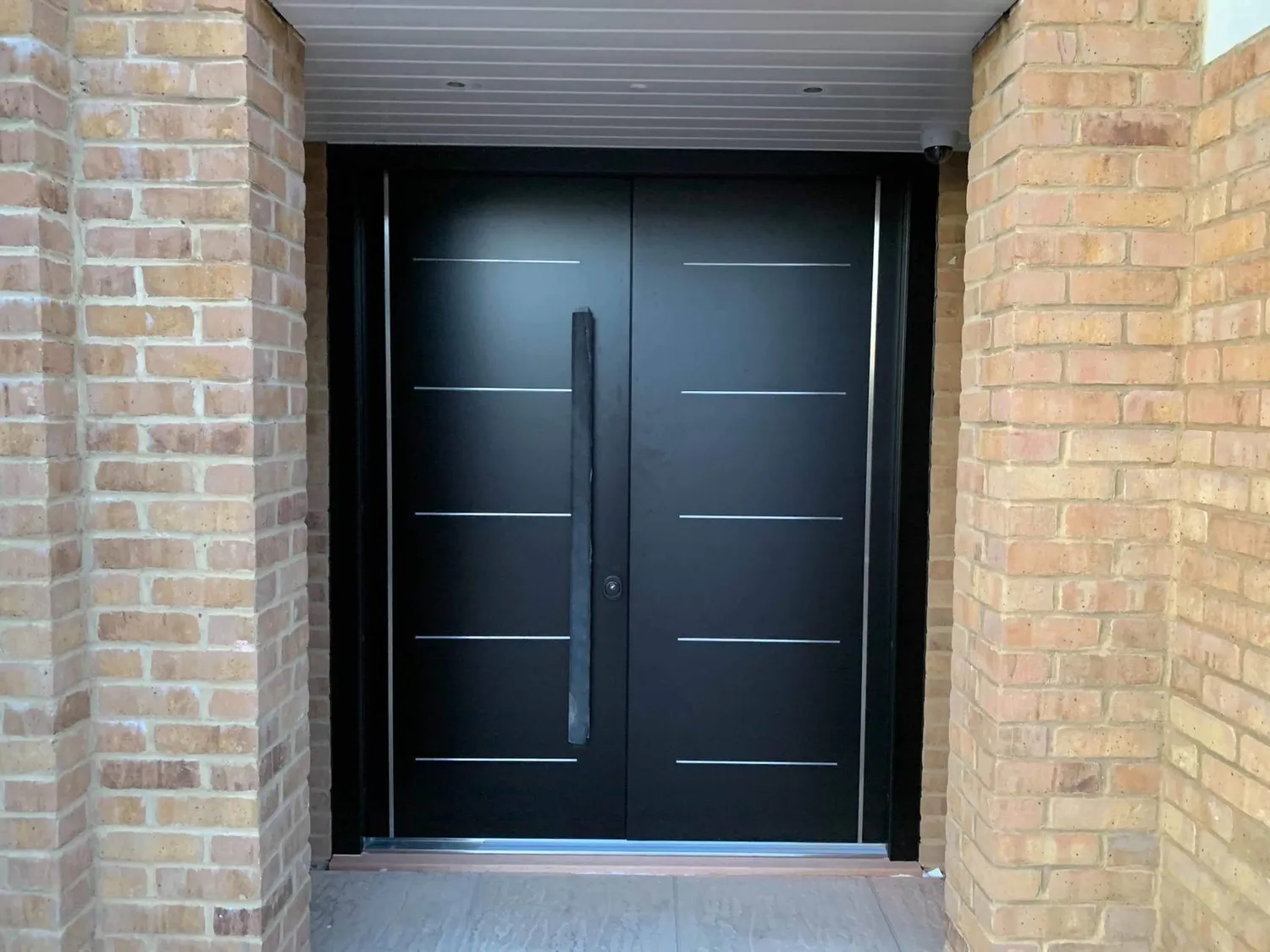 Steel security front door installed in a brick porch