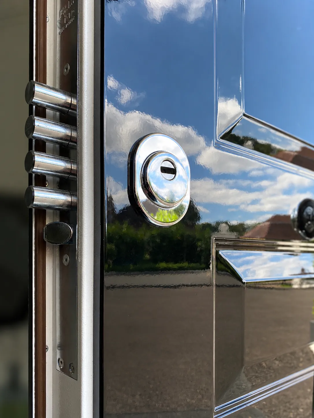 Chrome deadbolts and a snap-resistant cylinder escutcheon on a gloss-black security door